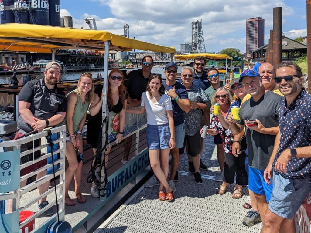 Group photo in front of a party boat with a yellow roof